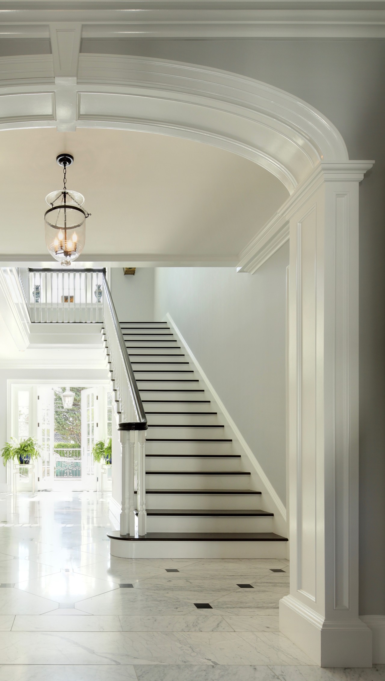 Brentwood stair hall with white marble floor with black cabochons